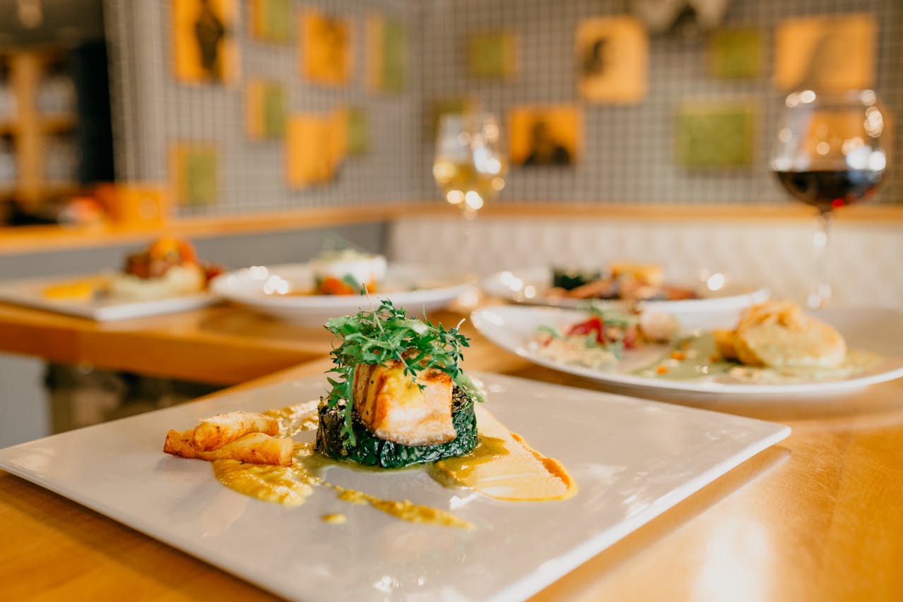 The Art of Drawing Readers In: Your attractive post title goes here Various appetizing dishes served on white plates and glasses of wine on wooden table in modern light restaurant